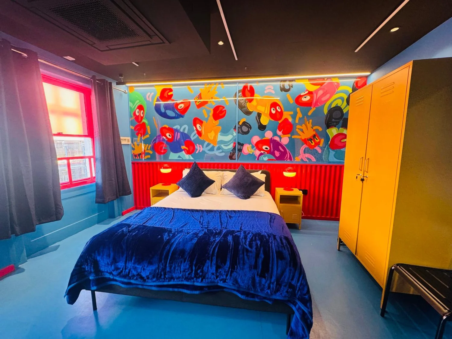 letto-coperte-blu-finestra-rossa